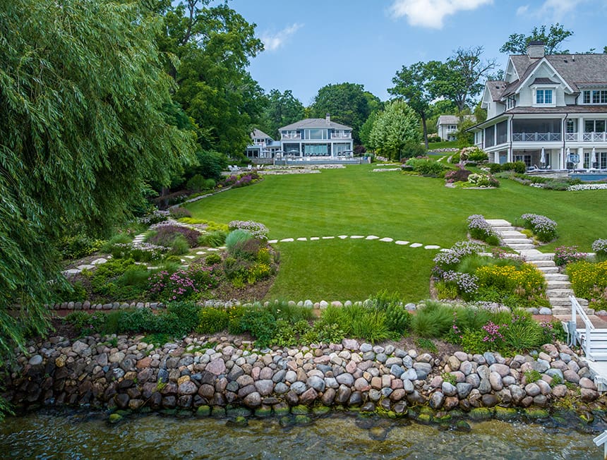 Terraced hillside landscape with stone steps and plantings leading toward the lake at a lakeside property in Williams Bay, Wisconsin.