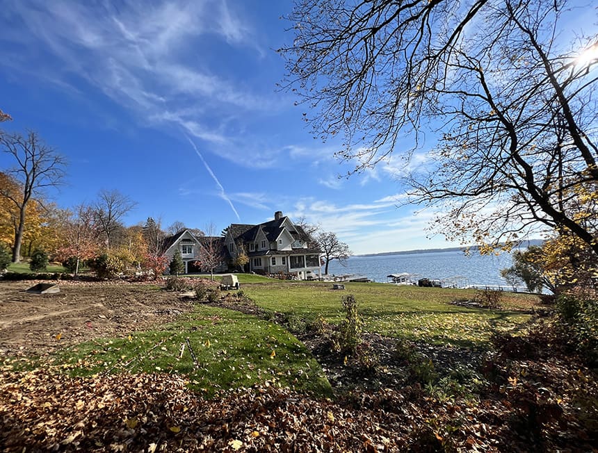 Before renovation view of an open lakeside lawn in Williams Bay, Wisconsin, without defined fire pit or seating area.